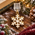 Cremeweiße Emaille-Schneeflocke mit goldfarbenen Details als USB-C Dust Plug am Kindle